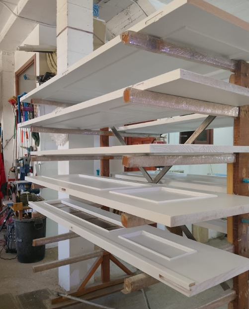 Puertas lacadas en blanco secándose en el taller